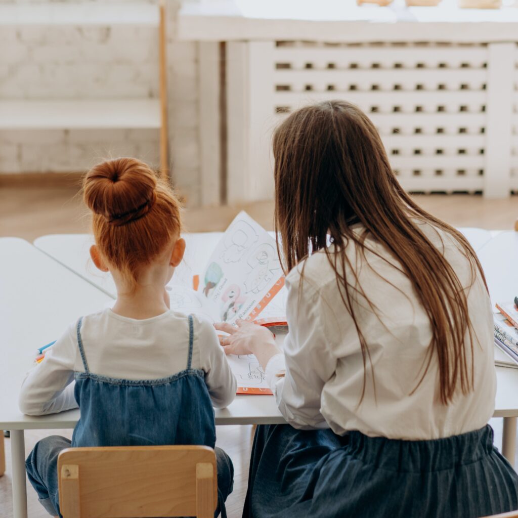 Nachhilfeschülerin und Nachhilfelehrerin von hinten beim Lernen